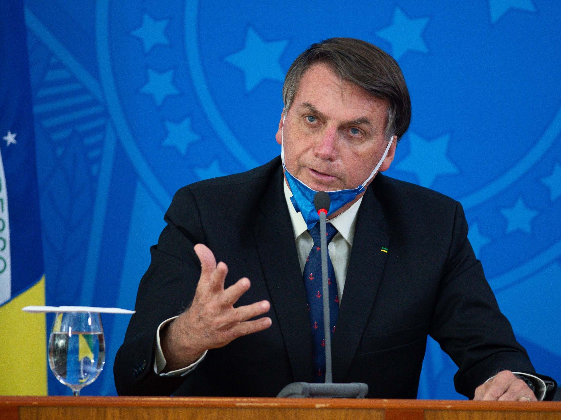 Jair Bolsonaro, president of Brazil, removes his face mask to speak during a press conference about the Covid-19 outbreak at the Planalto Palace, in Brazil, 20 March 2020. ( Andressa Anholete/Getty Images)