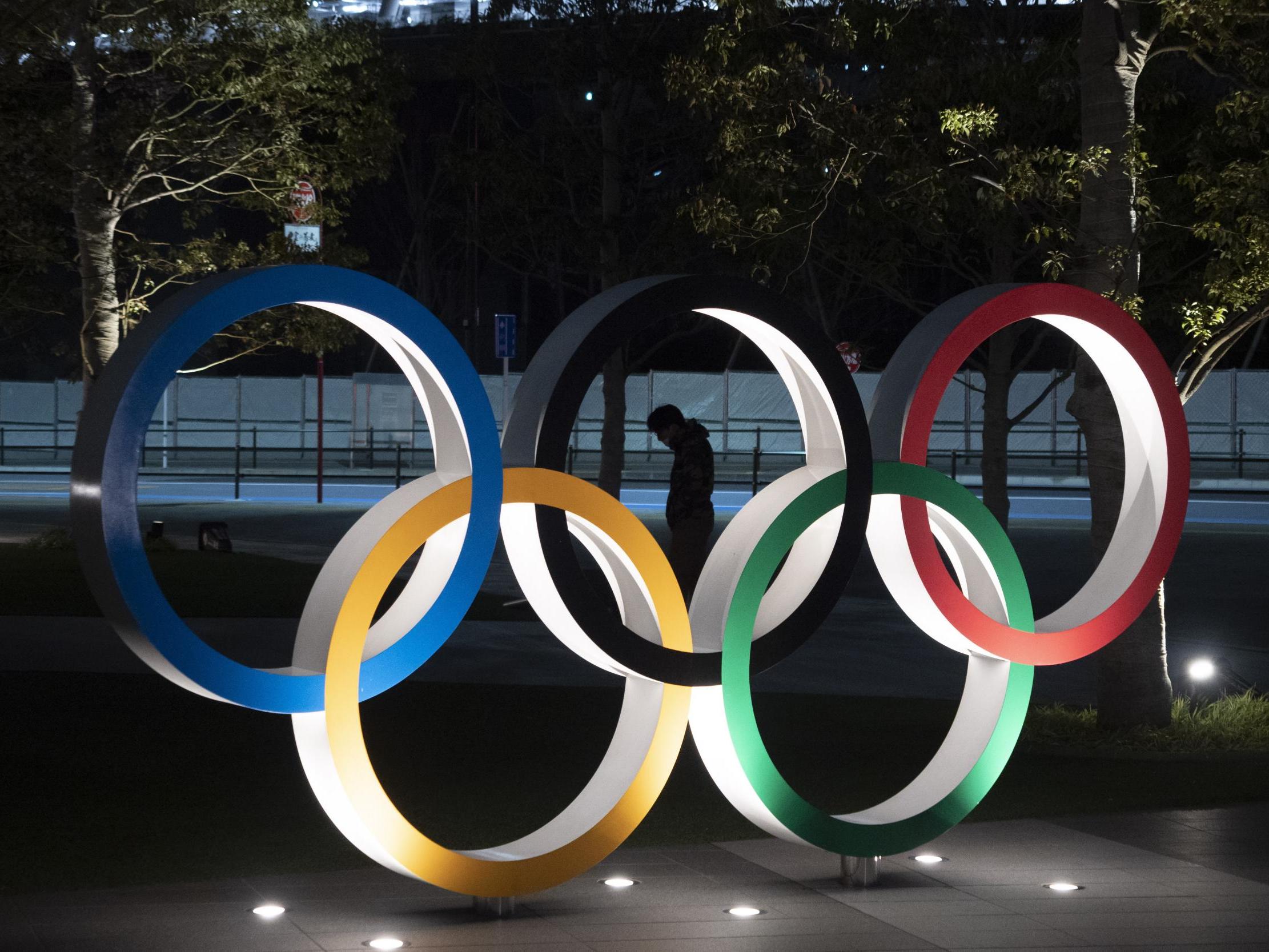 A man is seen through the Olympic rings