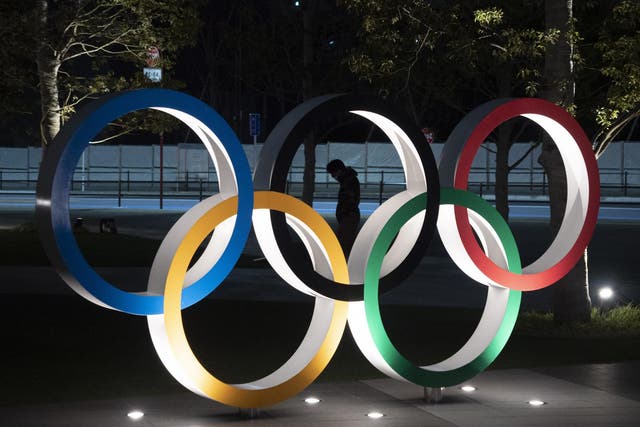 A man is seen through the Olympic rings