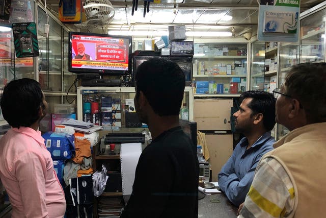 Indians watch on television as Narendra Modi addresses the nation amid concerns of a coronavirus outbreak in Delhi