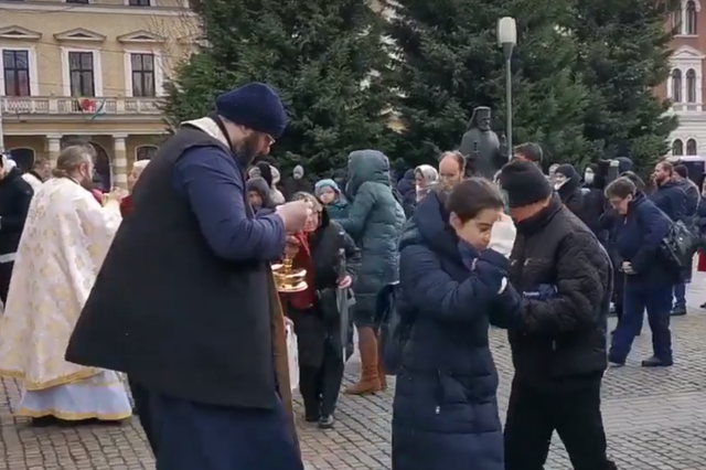Romanian priests give communion with a shared spoon on 22 March, 2020, amid concern over coronavirus.