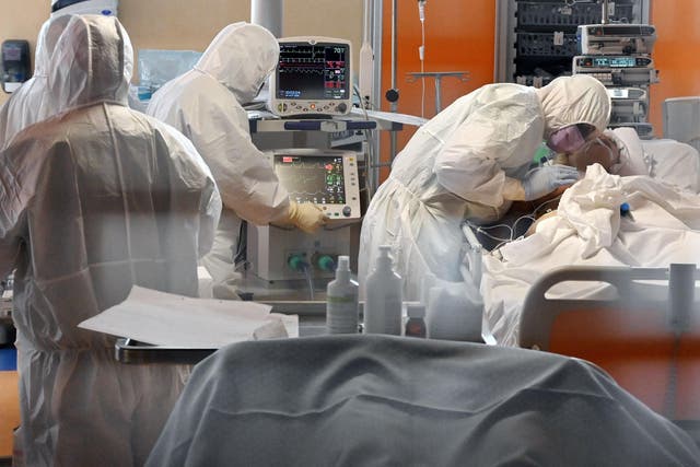 A medical worker in protective gear tends to a Covid-19 patient at a hospital in Rome, during the country's lockdown