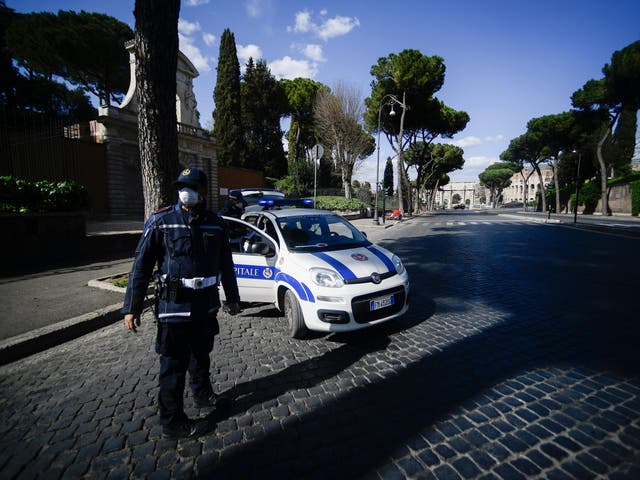 Municipal police officers check traveling permits on a deserted road in central Rome during the country's lockdown over its coronavirus outbreak