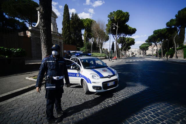 Municipal police officers check traveling permits on a deserted road in central Rome during the country's lockdown over its coronavirus outbreak