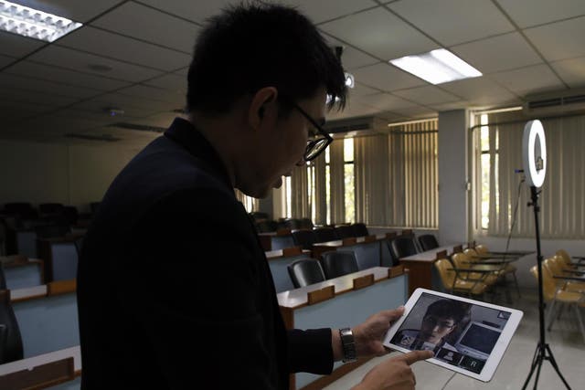 A lecturer speaks to students via a video-conference app in Thailand