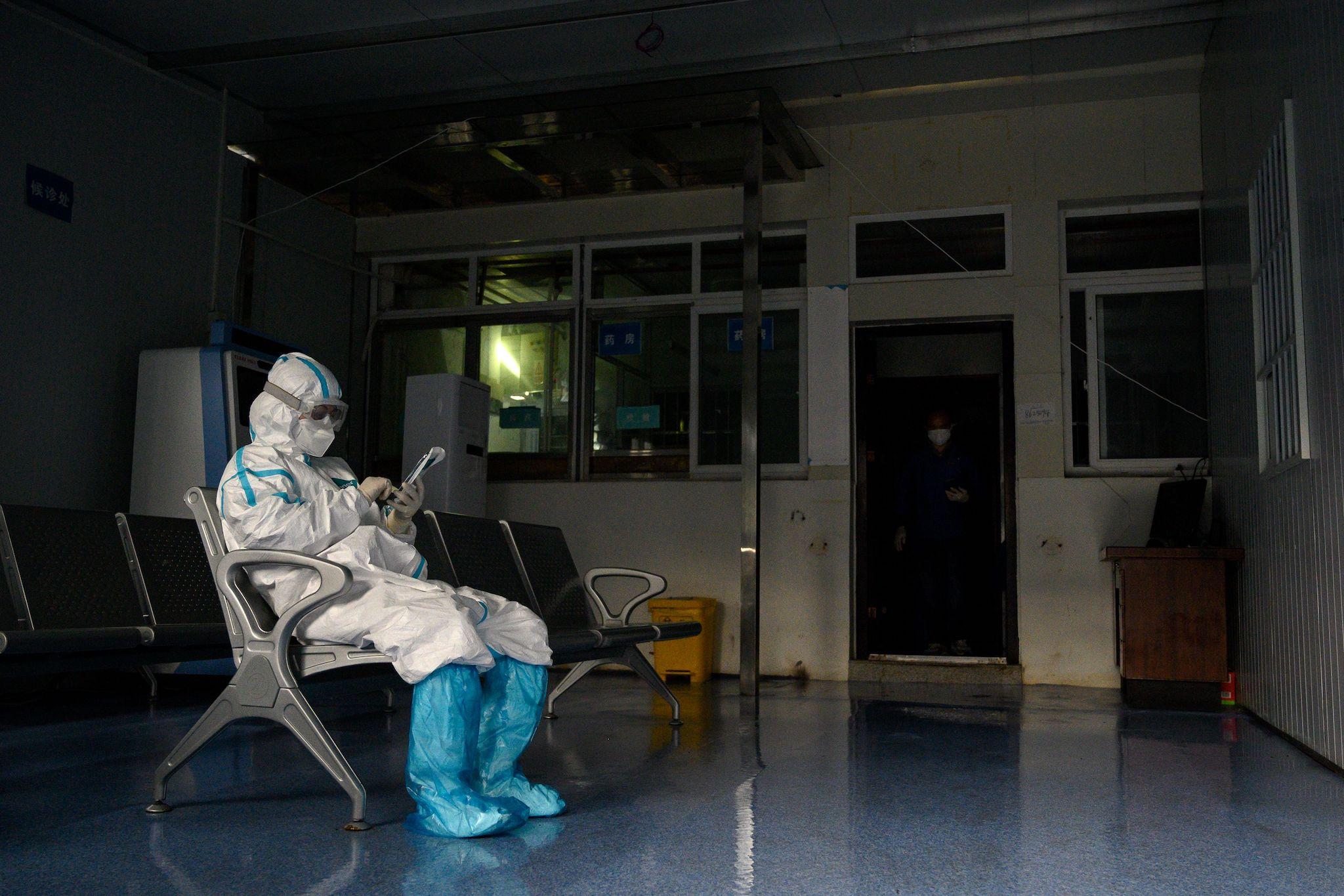 Medical workers wearing hazmat suits as a preventive measure against the COVID-19 coronavirus takes a rest at a fever clinic in Huanggang Zhongxin Hospital in Huanggang