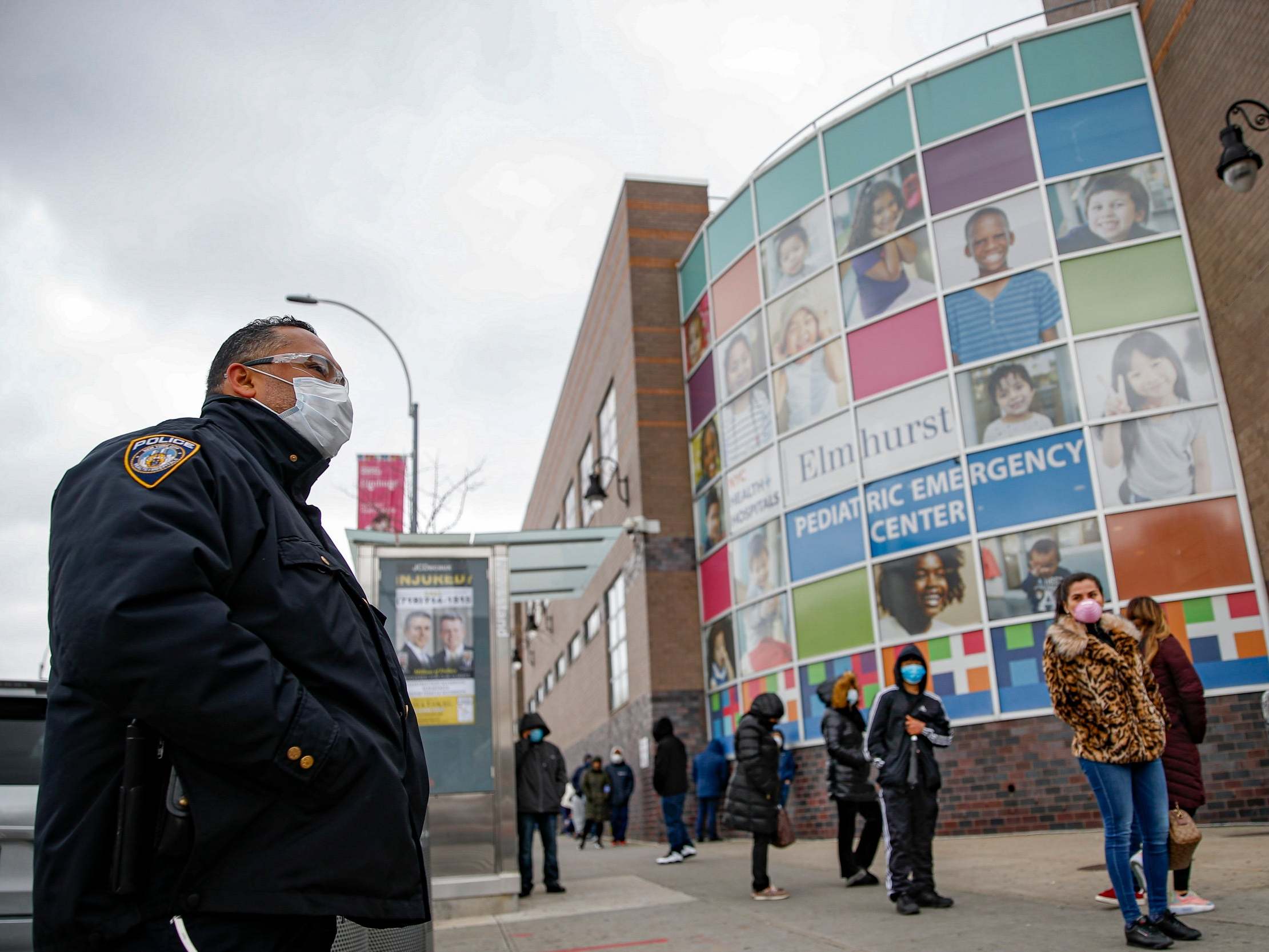 An NYPD officer wears personal protective equipment while maintaining order at a coronavirus testing site