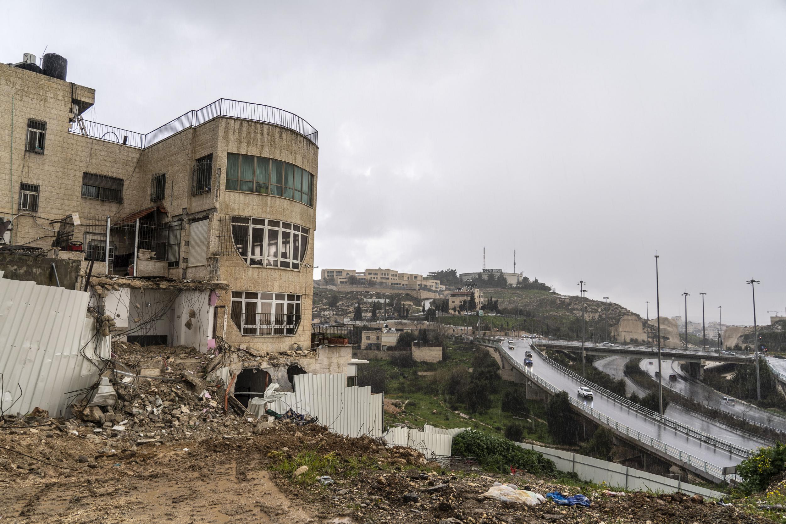 The demolished Bashiti home in the rain with Pisgat Ze’ev settlement in the background