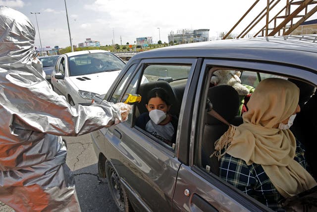Members of the Iranian Red Crescent test people for coronavirus Covid-19 symptoms, as police blocked Tehran to Alborz highway