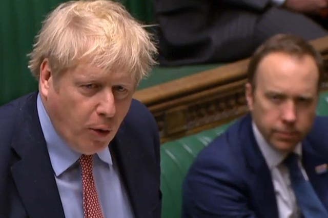 Britain's Health Secretary Matt Hancock (R) listening as Britain's Prime Minister Boris Johnson speaks