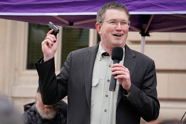 Rep Thomas Massie (R-KY) draws a handgun from his pocket during a rally in support of the Second Amendment on 31 January, 2020. Mr Massie is now threatening to delay the passage of the coronavirus stimulus bill.