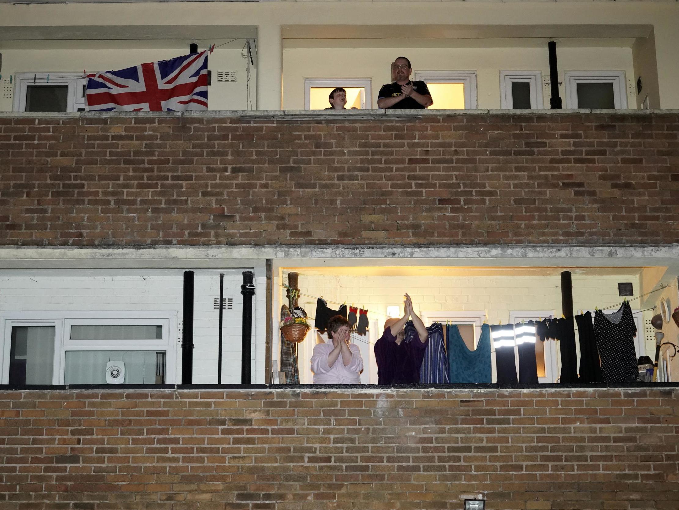 People applauding from their balconies as part of the Clap For Our Carers campaign 26 March 2020