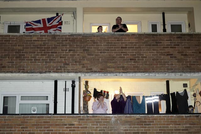 People applauding from their balconies as part of the Clap For Our Carers campaign 26 March 2020