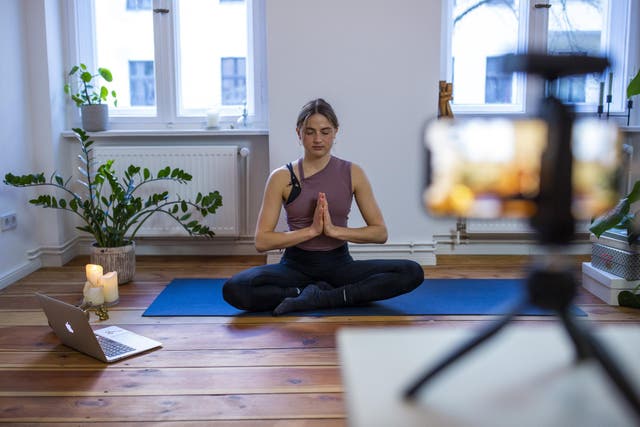 Marlene of Yoga on the Move Berlin warms up prior to conducting an online session in her home on March 25, 2020 in Berlin, Germany
