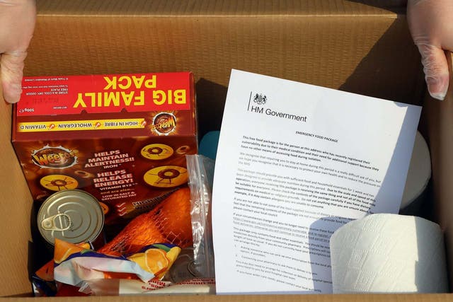 Communities secretary Robert Jenrick helps deliver a food parcel containing oranges, toilet paper and chocolate-flavour Weetos