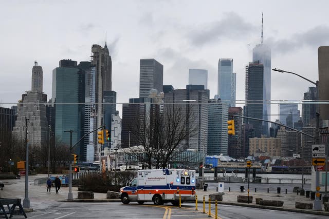 An ambulance pauses in Brooklyn while lower Manhattan looms in the background