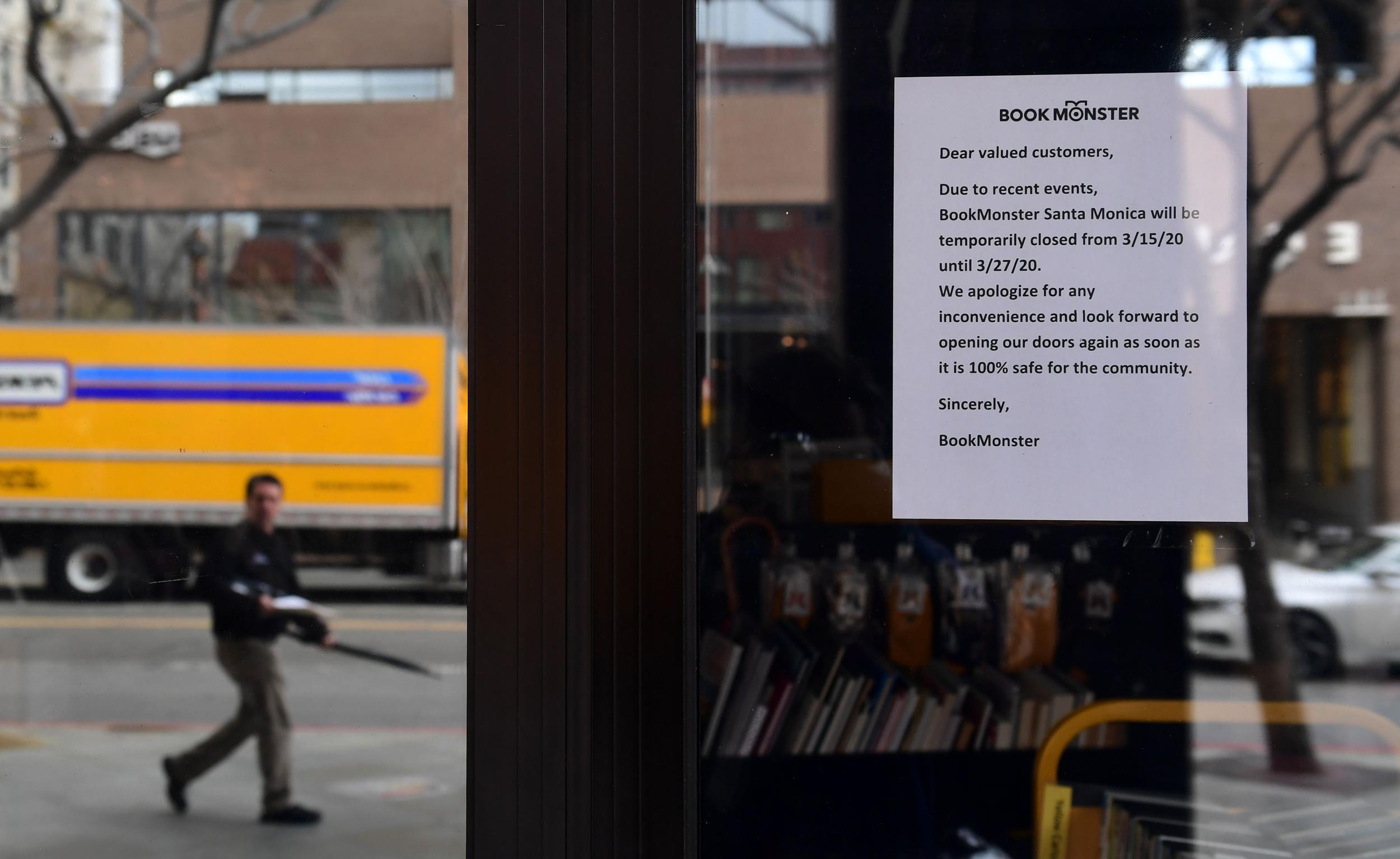 A sign for temporary closure is posted in front of the Book Monster bookstore in Santa Monica, California on 16 March 2020.