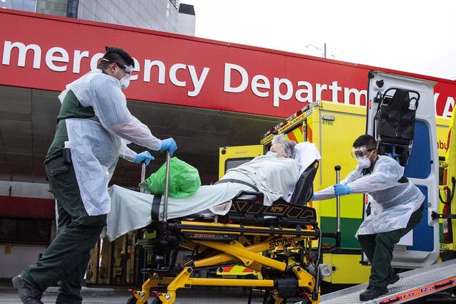 A woman is wheeled from an ambulance at St Thomas' Hospital in London, UK, 30 March 2020.