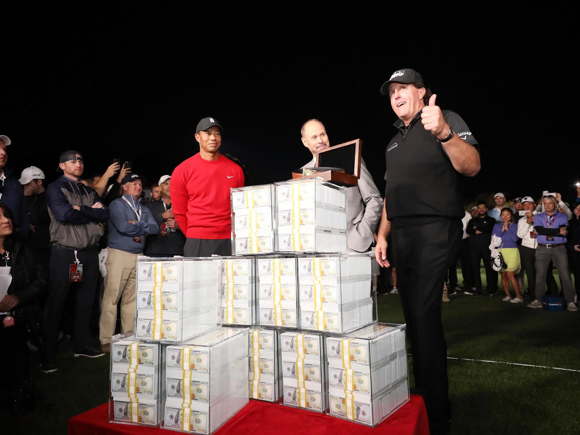 Phil Mickelson poses with $9m after defeating Tiger Woods