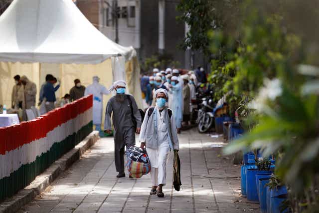 <p>File image: Muslim visitors leaving the Nizamuddin Markaz walk towards a bus to take them to a quarantine facility</p>