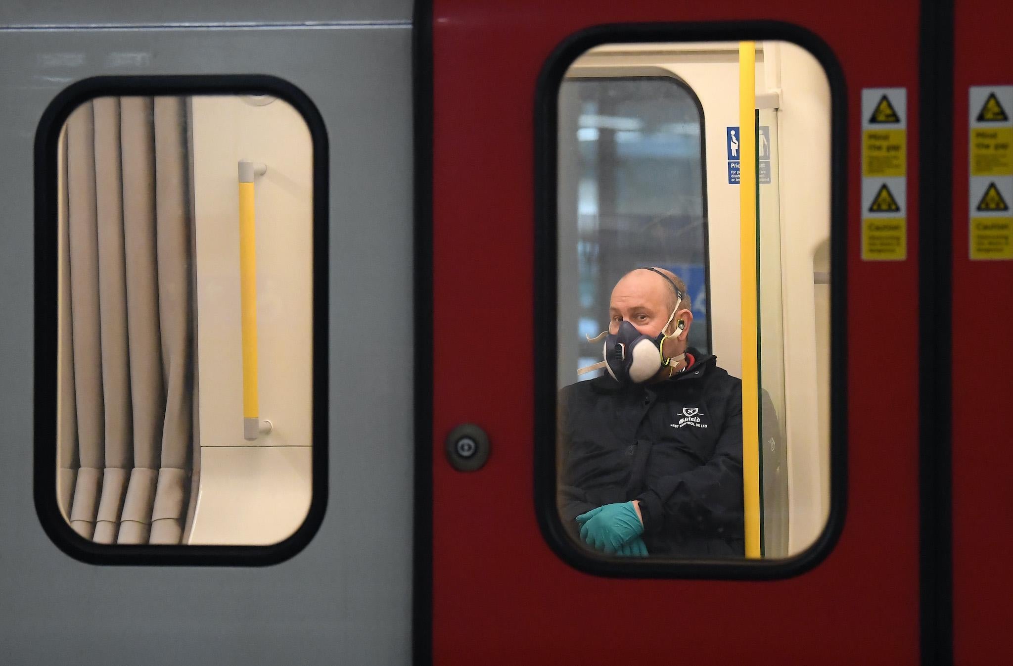 A member of the public wears a a protective mask on the Tube on March 25, 2020 in London, England. British Prime Minister, Boris Johnson, announced strict lockdown measures urging people to stay at home and only leave the house for basic food shopping, exercise once a day and essential travel to and from work