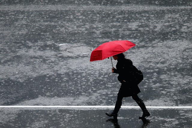 A pedestrian crosses in the intersection of Queen Street and Victoria Street during heavy rain on July 1, 2014 in Auckland, New Zealand