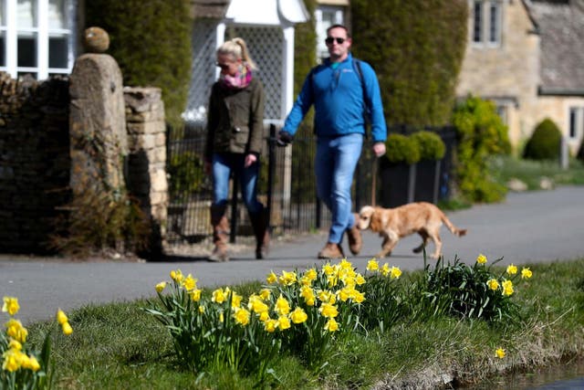 Dog walkers enjoy the sunshine Lower Slaughter, Cotswolds, Gloucestershire, 29 March 2020.