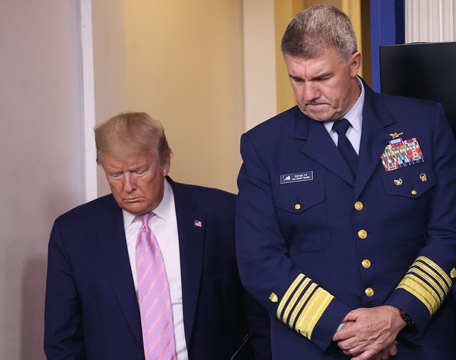 Donald Trump arrives for a White House briefing during the coronavirus pandemic as US Coast Guard Commandant Admiral Karl Schultz looks on