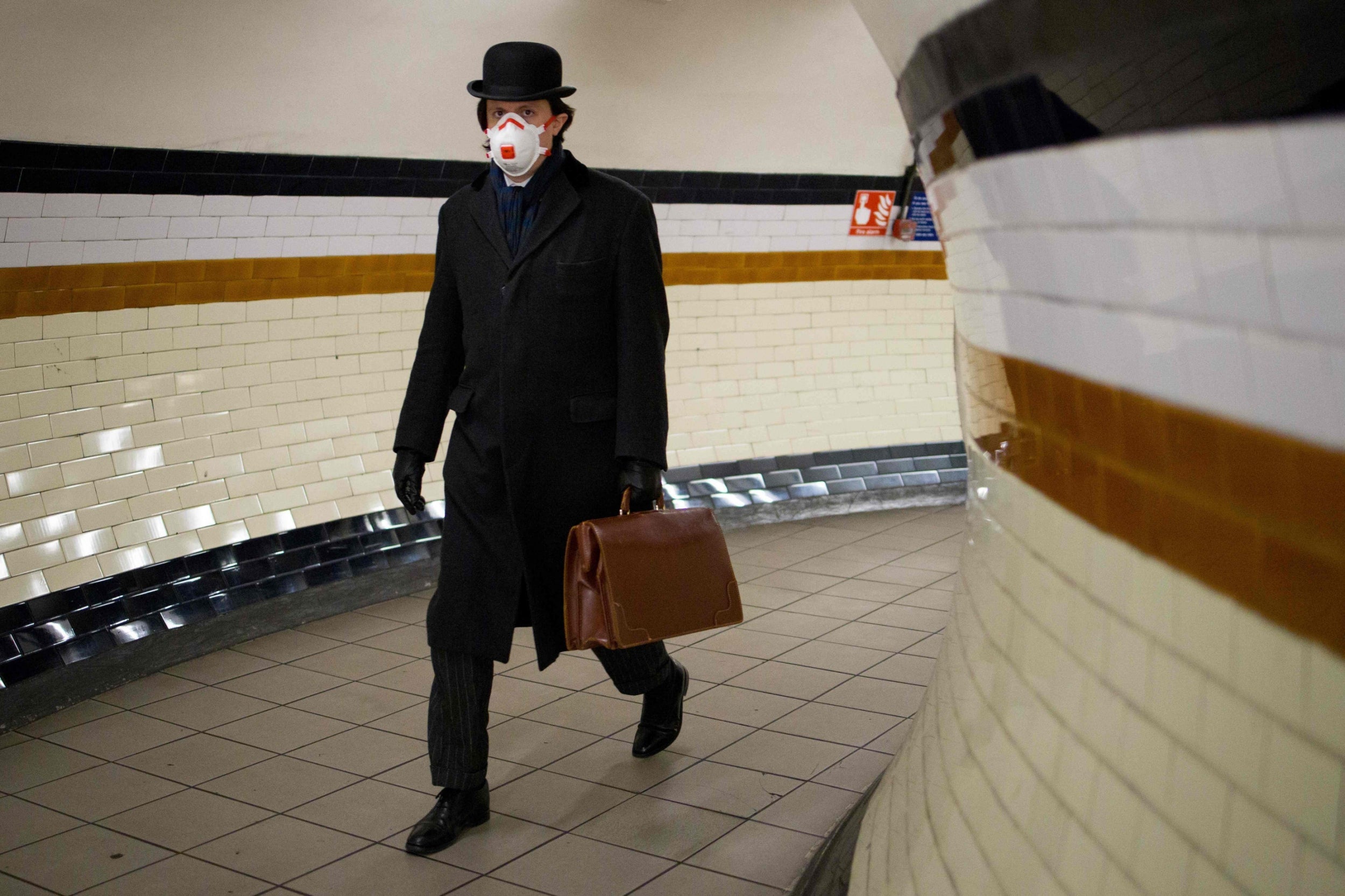 A commuter wears a face mask as he walks at Lambeth North station to a Bakerloo line train on the London Underground on 2 April