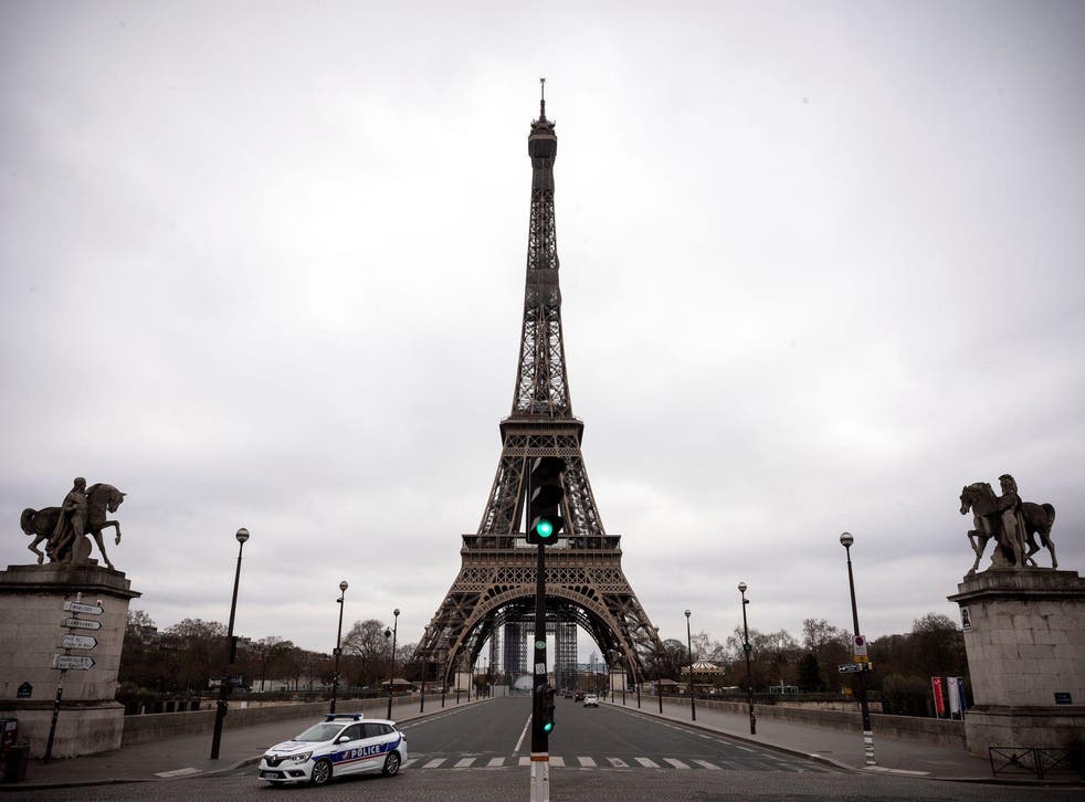 A police car drives past the Eiffel Tower on 21 March on the fifth day of a strict nationwide lockdown