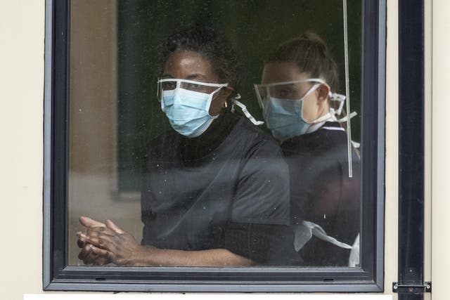 Nurses clean their hands before taking swabs at a Covid-19 Drive-Through testing station for NHS staff on March 30, 2020 in Chessington, United Kingdom