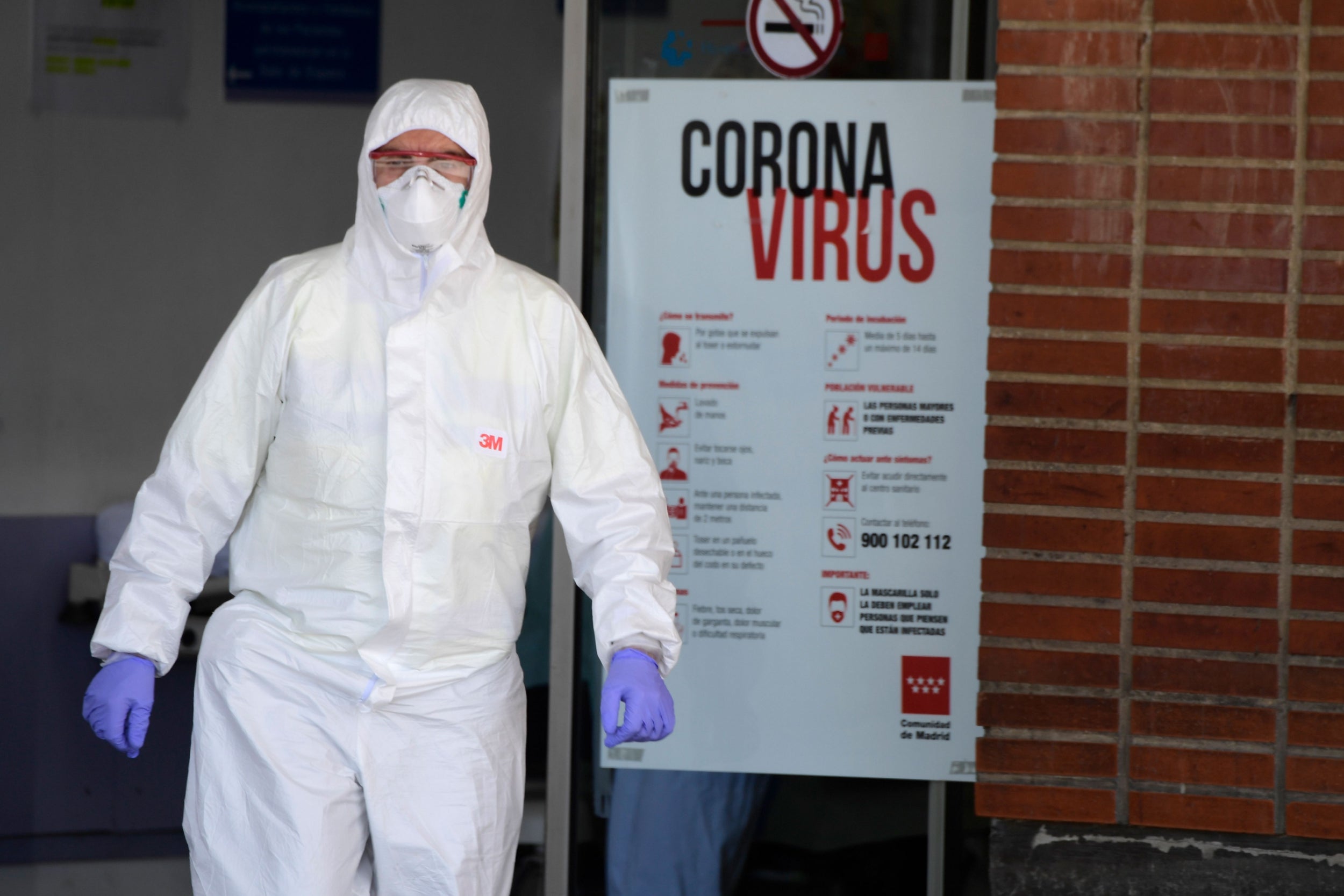 A healthcare worker wearing a protective suit at the entrance of the Severo Ochoa Hospital in Leganes, near Madrid, on Friday