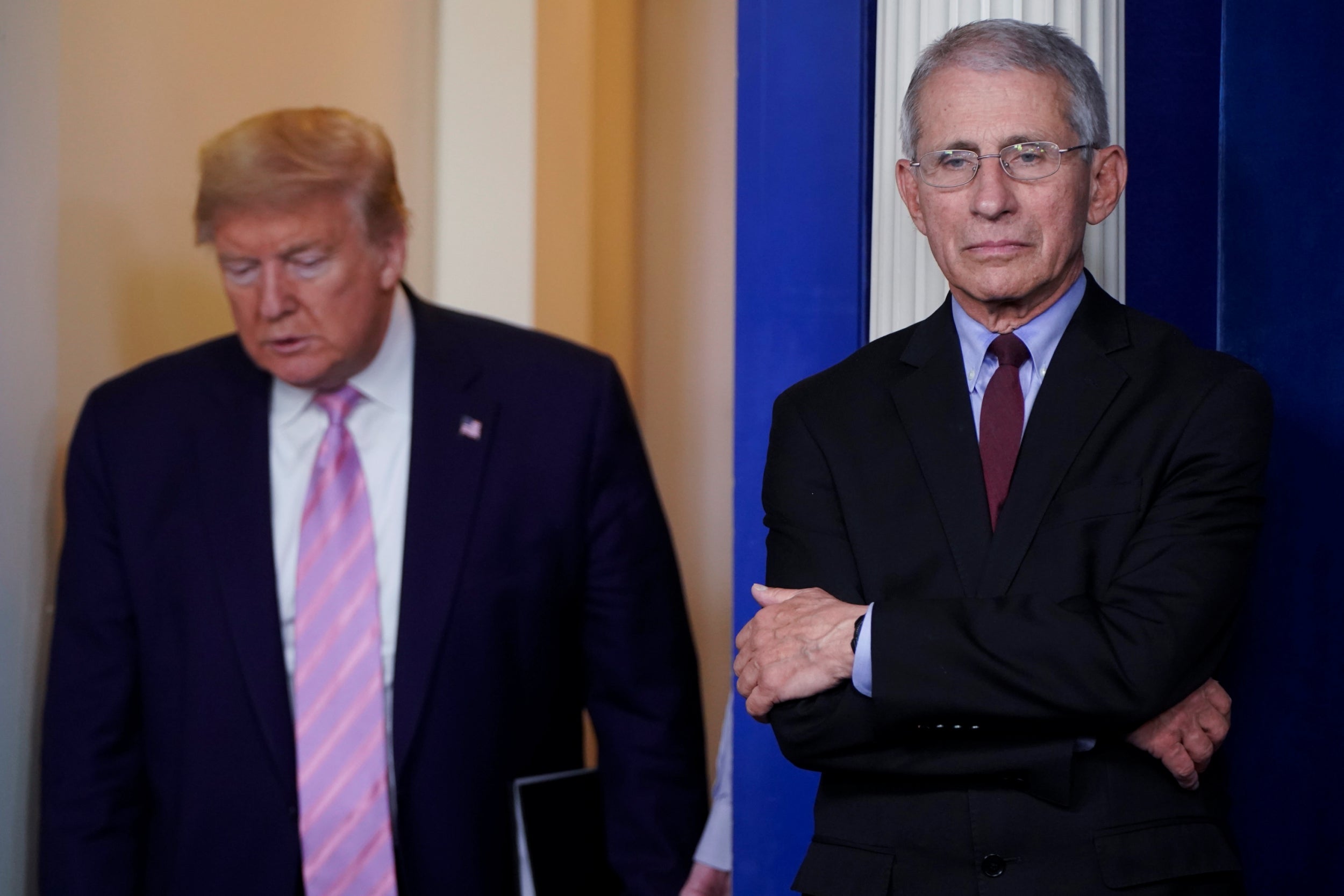 Donald Trump arrives for a White House briefing on the coronavirus pandemic as Anthony Fauci looks on