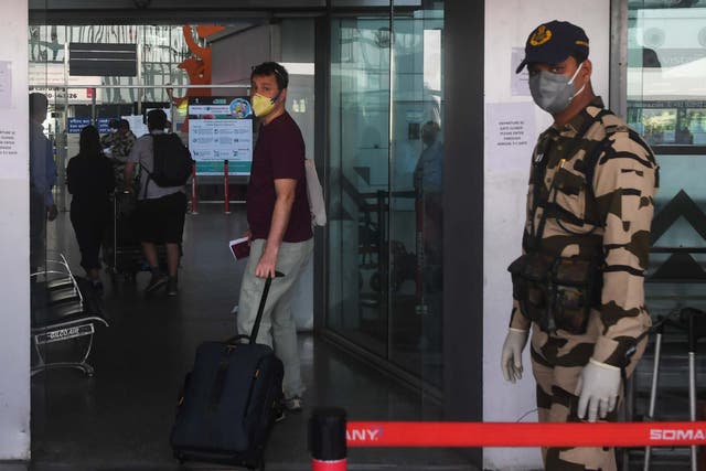 A foreign national wearing a facemask enters the departure terminal of the Netaji Subhash Chandra Bose International Airport to board a special evacuation flight