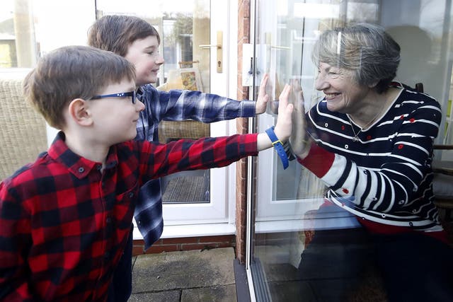 Ben and Isaac talk to their grandmother Sue through a window, as she and her husband Alan self-isolate at their home in Cheshire