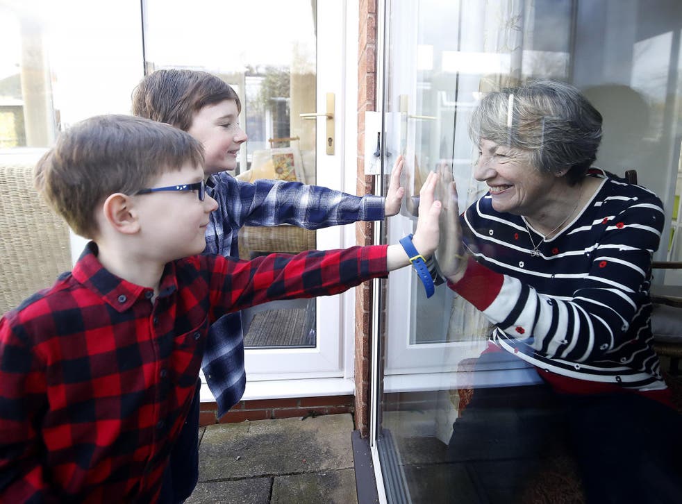 Ben and Isaac talk to their grandmother Sue through a window, as she and her husband Alan self-isolate at their home in Cheshire