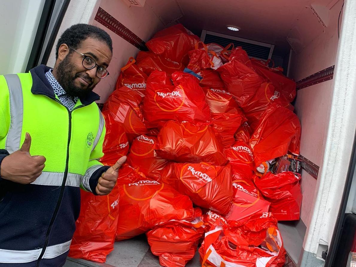 City Harvest volunteer Mohamed Elmi picking up surplus biscuits from TK Maxx