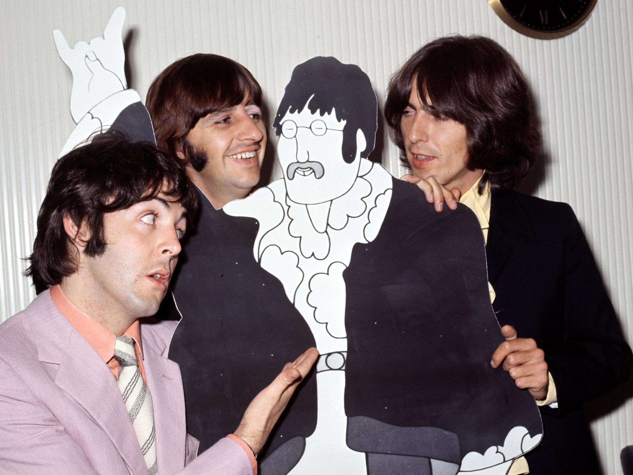 Paul McCartney, Ringo Starr and George Harrison pose with a cardboard John Lennon cut out in his absence in 1968