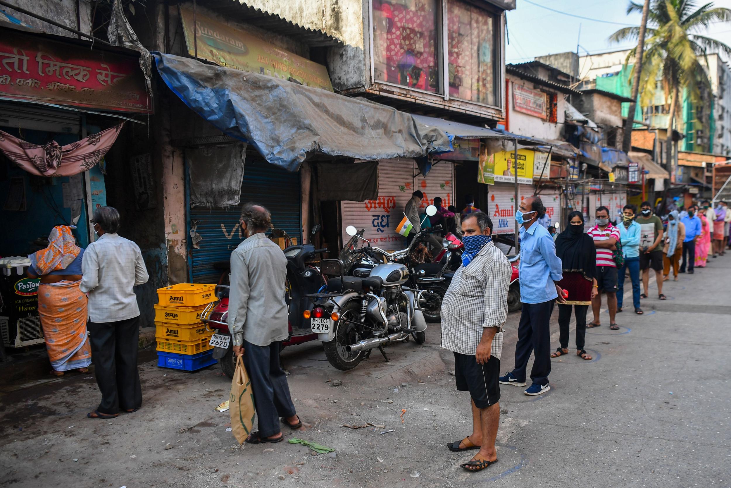 Residents queue up to collect milk inside the Dharavislum during the government-imposed nationwide lockdown