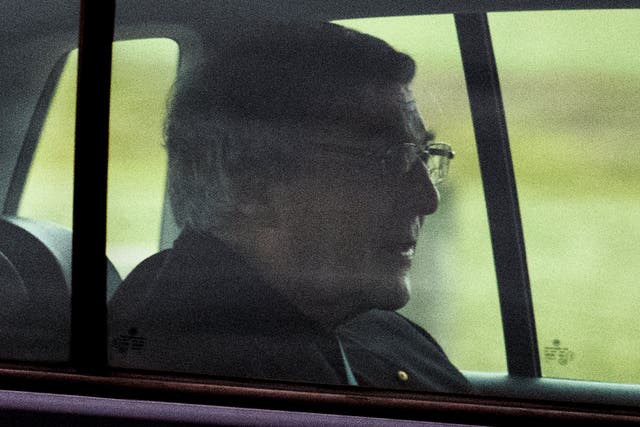 Cardinal George Pell sits in the back seat of a car as he leaves prison in Melbourne on Tuesday