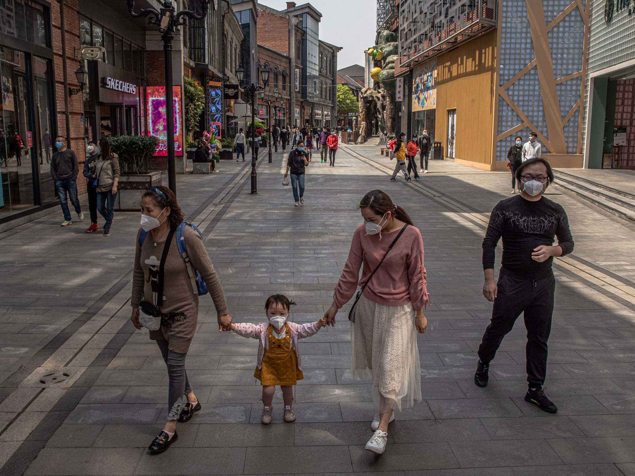 A family goes shopping in Wuhan, China, as the city prepares to lift the lockdown after more than two months