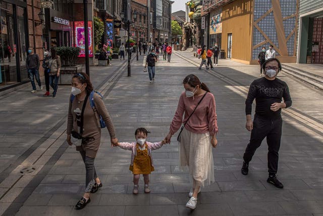 A family goes shopping in Wuhan, China, as the city prepares to lift the lockdown after more than two months