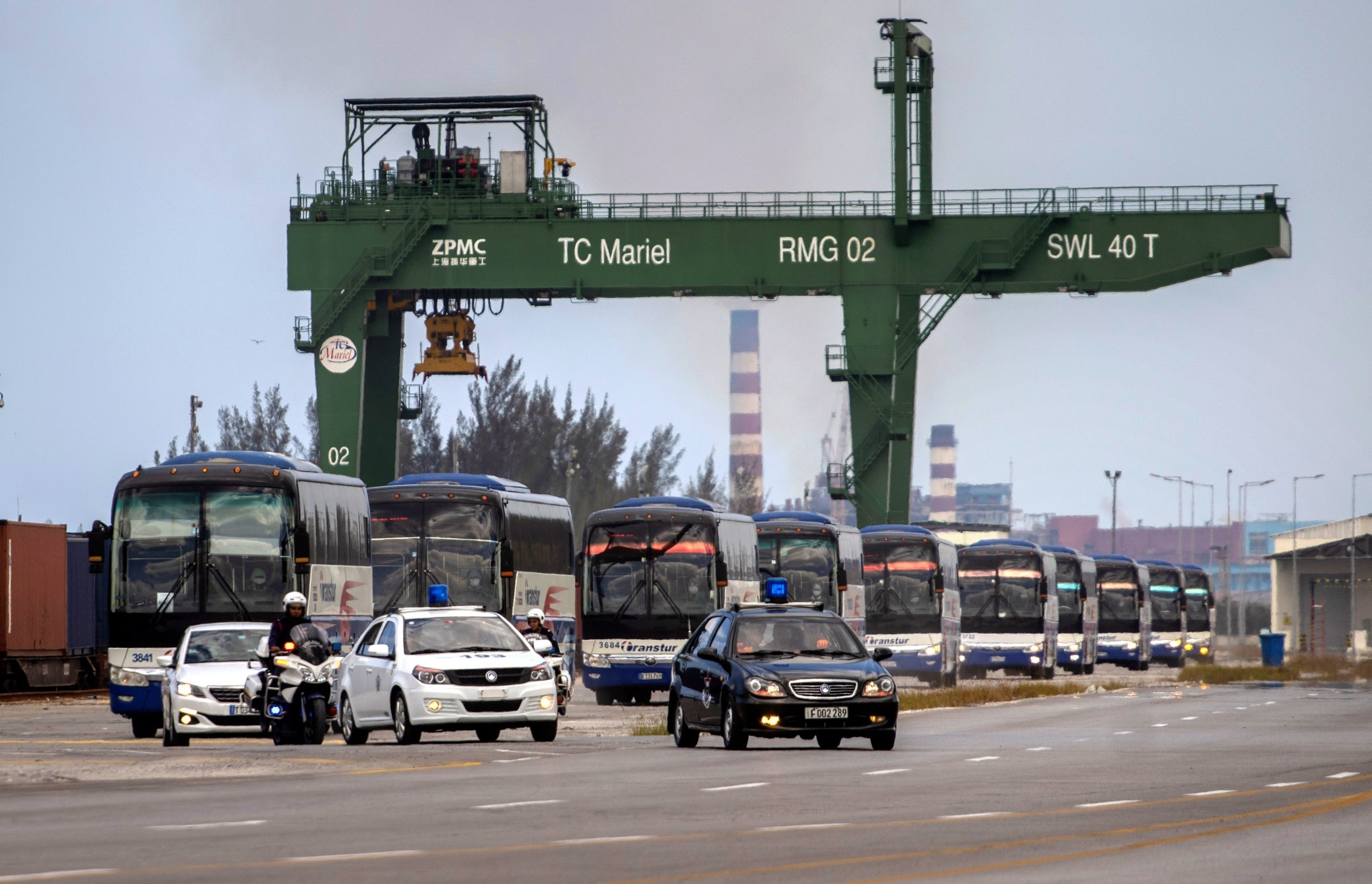 Buses escorted by police transport carry holidaymakers to an airport near Havana