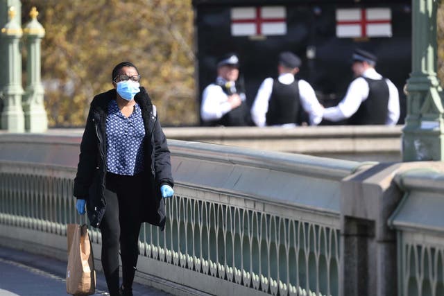 A woman walks across Westminster Bridge in London as the UK continues in lockdown to help curb the spread of the coronavirus.