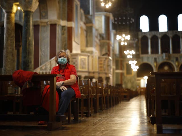 A lone worshipper sits on a pew in Westminster Cathedral