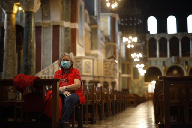 A lone worshipper sits on a pew in Westminster Cathedral