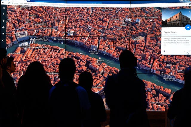 A person looks at a Google Earth map of Venice, Italy on a screen as Google Earth unveils the revamped version of the application April 18, 2017 at a event at New York's Whitney Museum of Art