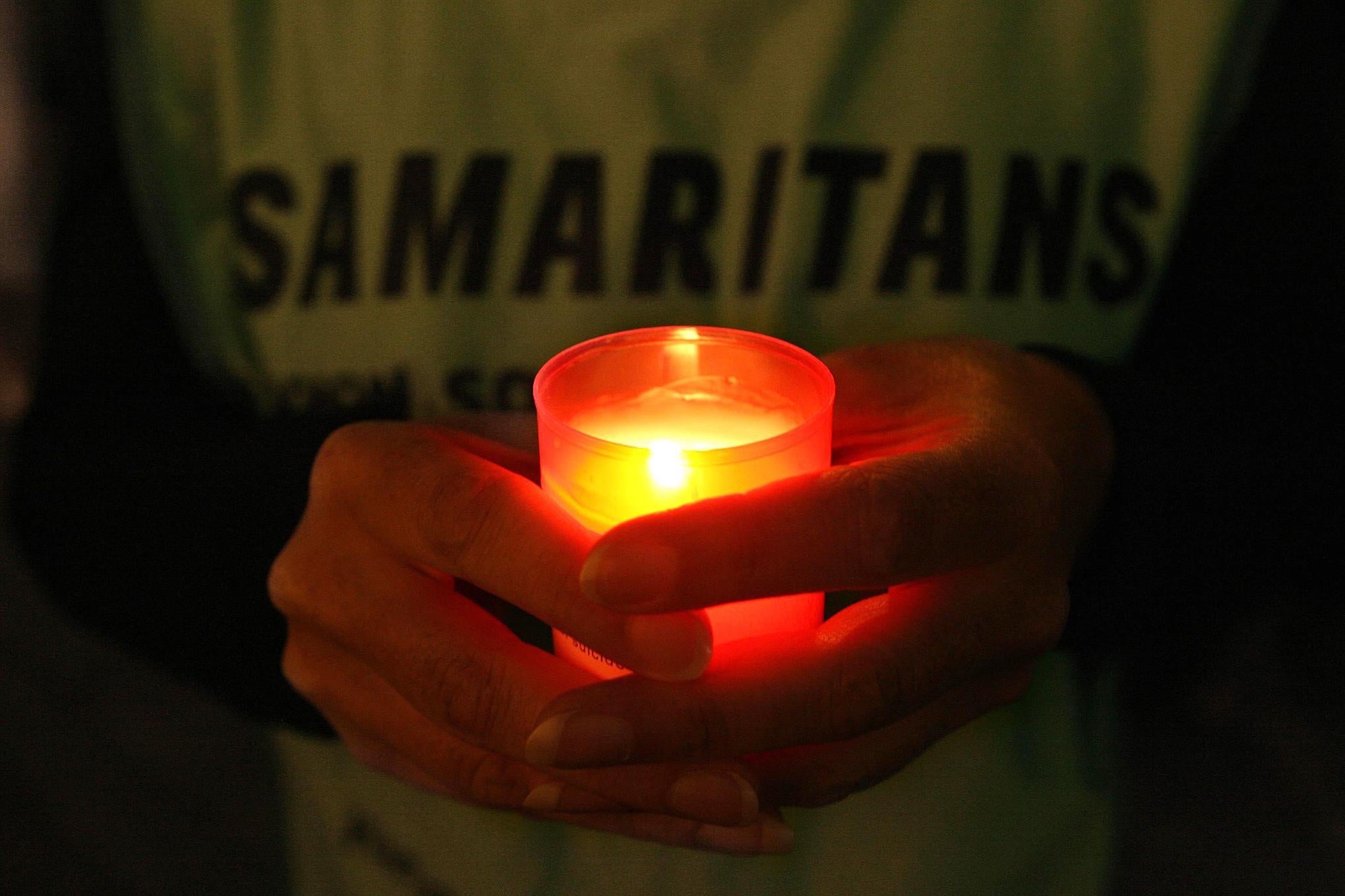 A Samaritans volunteer holds a candle during a vigil to mark World Suicide Prevention Day