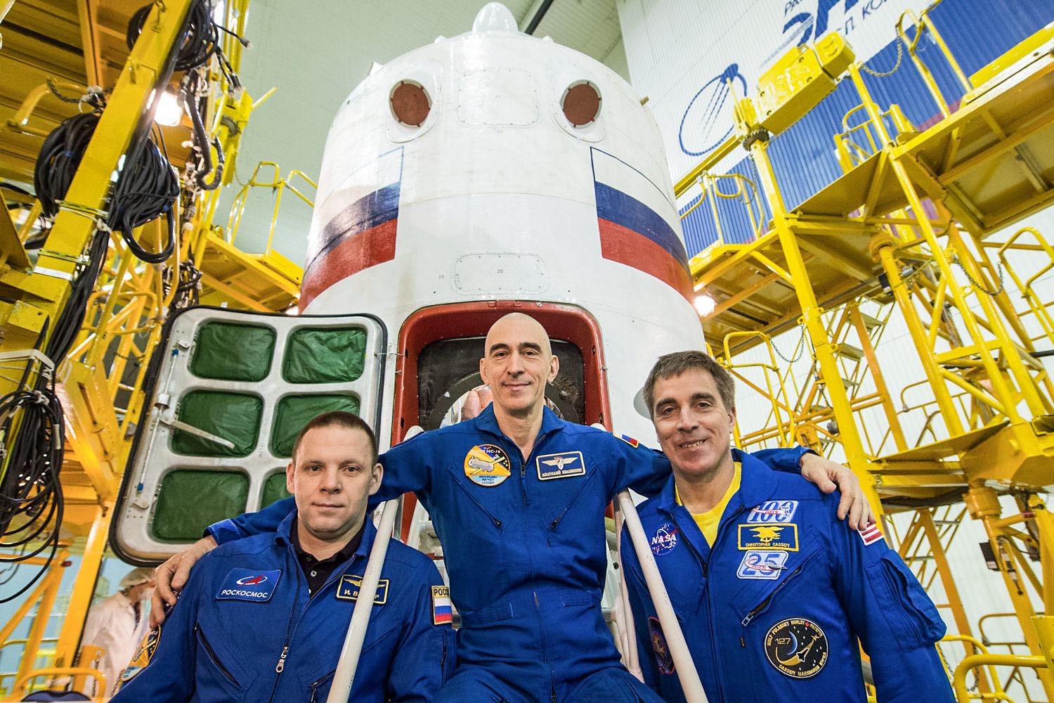 At the Baikonur Cosmodrome in Kazakhstan, Expedition 63 crew members Ivan Vagner (left) and Anatoly Ivanishin (center) of Roscosmos and NASA astronaut Chris Cassidy (right) pose for pictures April 3 in front of their Soyuz spacecraft as part of their prelaunch activities