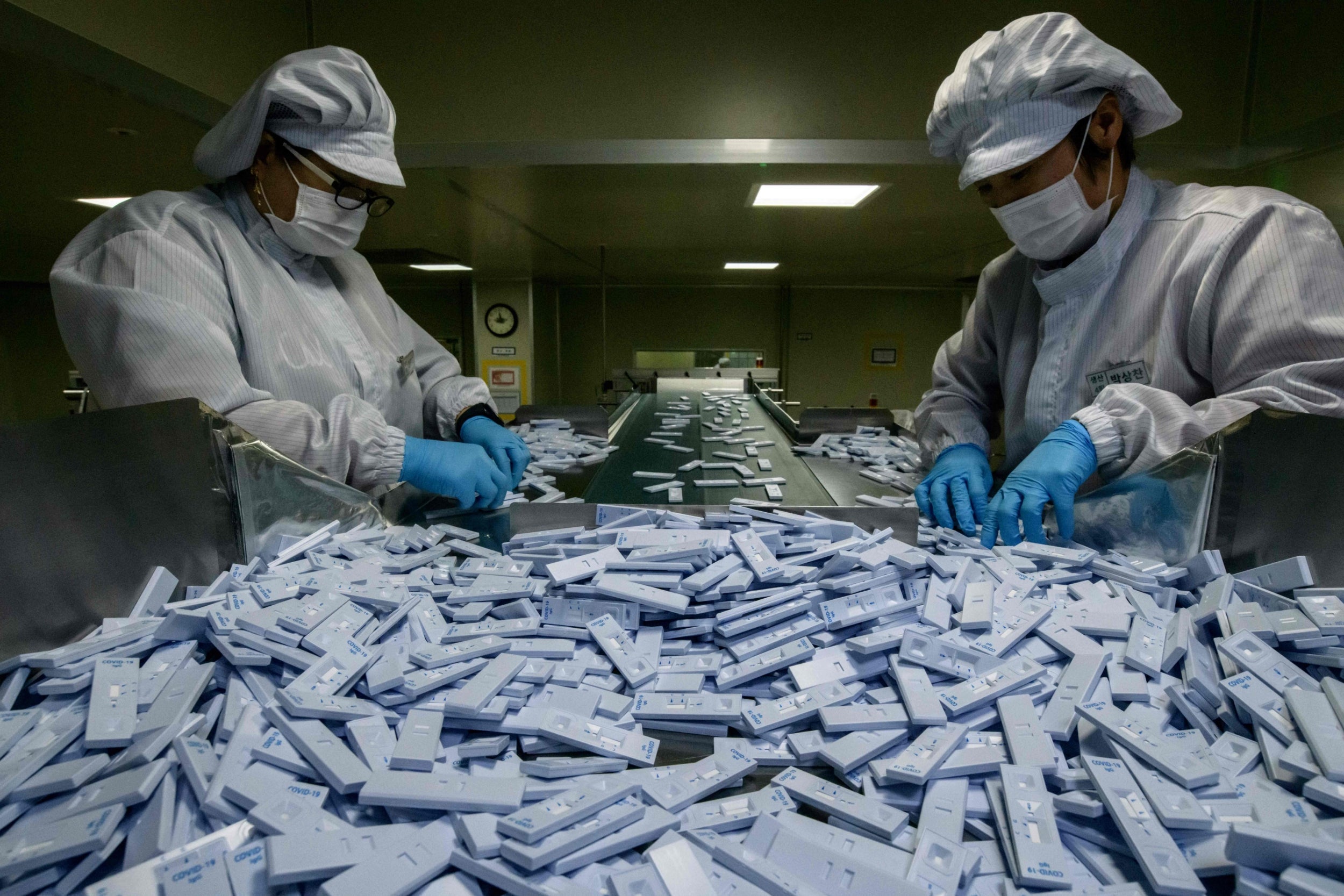 Sample testing devices used in diagnosing coronavirus are checked on a production line near Cheongju, south of Seoul
